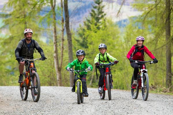 Una familia de ciclistas de montaña disfrutando de un día en el bosque de Glentress