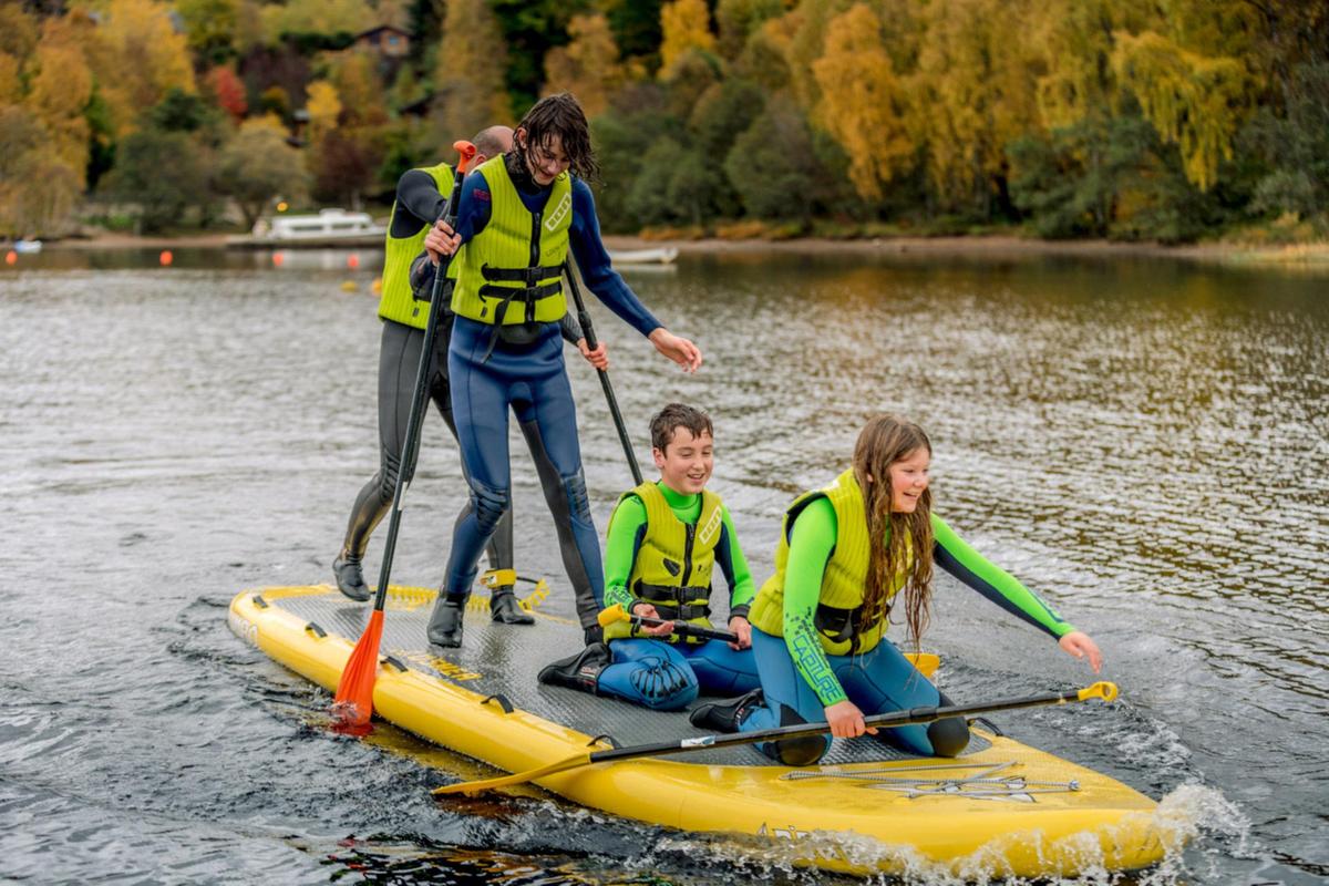 A family tries paddleboarding on Loch Insh, Cairngorms National Park